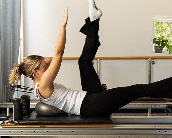 Woman performing reformer pilates