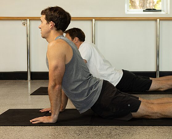 Two men in a mat pilates class